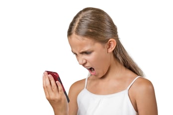 Closeup portrait young mad, frustrated angry teenager girl yelling while on phone isolated white background. Negative human emotion facial expression feelings. Communication, conflict resolution